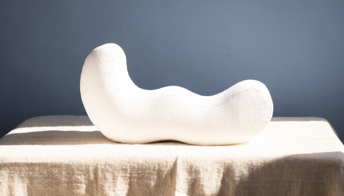 Oreiller ergonomique vu de profil, ses deux bourrelets de hauteurs différentes visibles